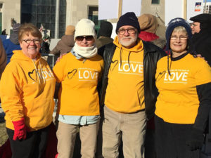Picture of four Peoples Church members in yellow Standing on the Side of Love shirts