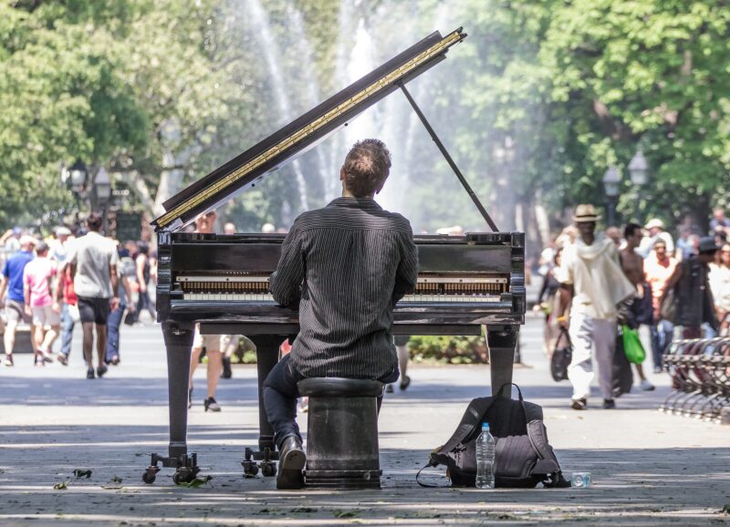 Photo of a man playing the piano in the park