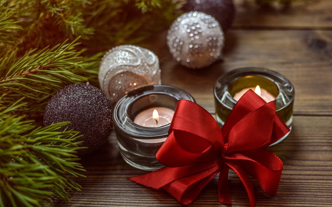 Picture of two small candles with greenery and a red bow